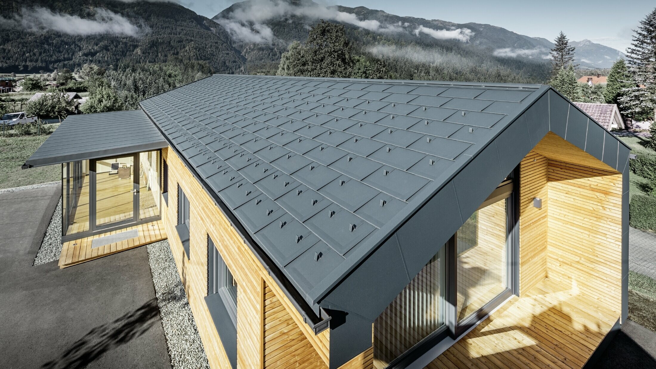 Nouvel immeuble de bureaux de Holzbau Faltheiner avec une façade en bois de mélèze, des fenêtres généreuses et une toiture PREFA en anthracite.