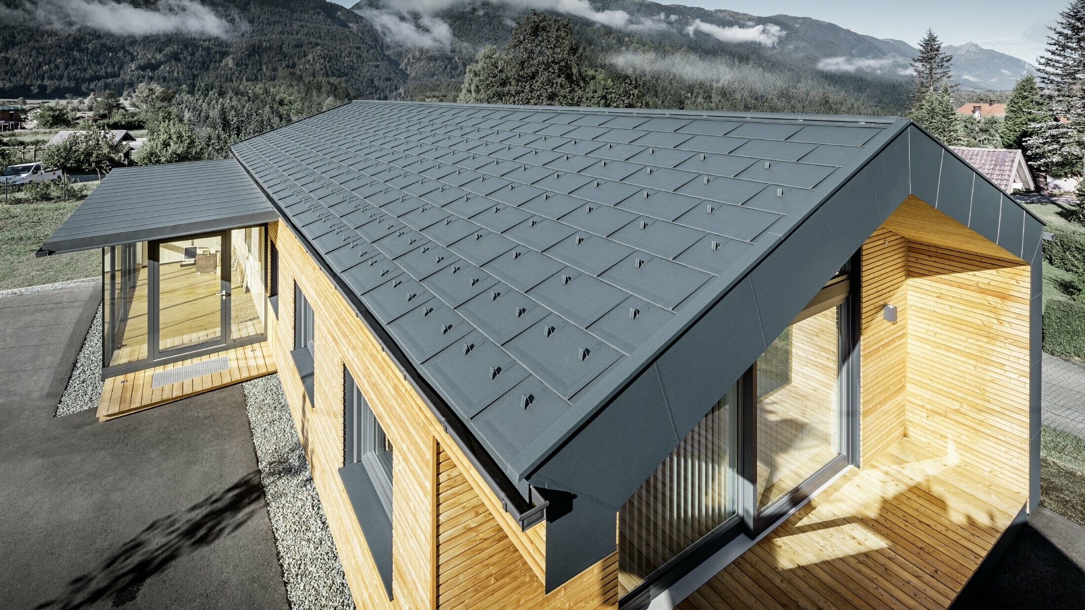 Nouvel immeuble de bureaux de Holzbau Faltheiner avec une façade en bois de mélèze, des fenêtres généreuses et une toiture PREFA en anthracite.