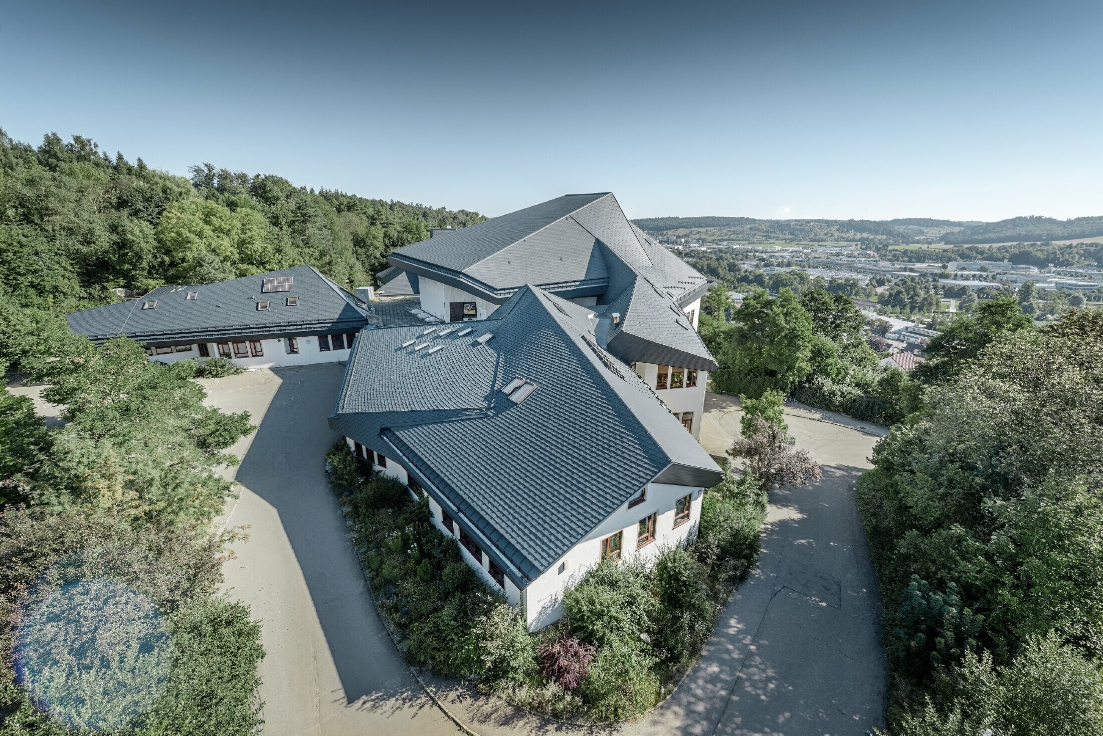 École Waldorf de Heidenheim au toit rénové — L’importante toiture aux nombreux angles, recoins et inclinaisons a été réalisée avec des bardeaux PREFA anthracite