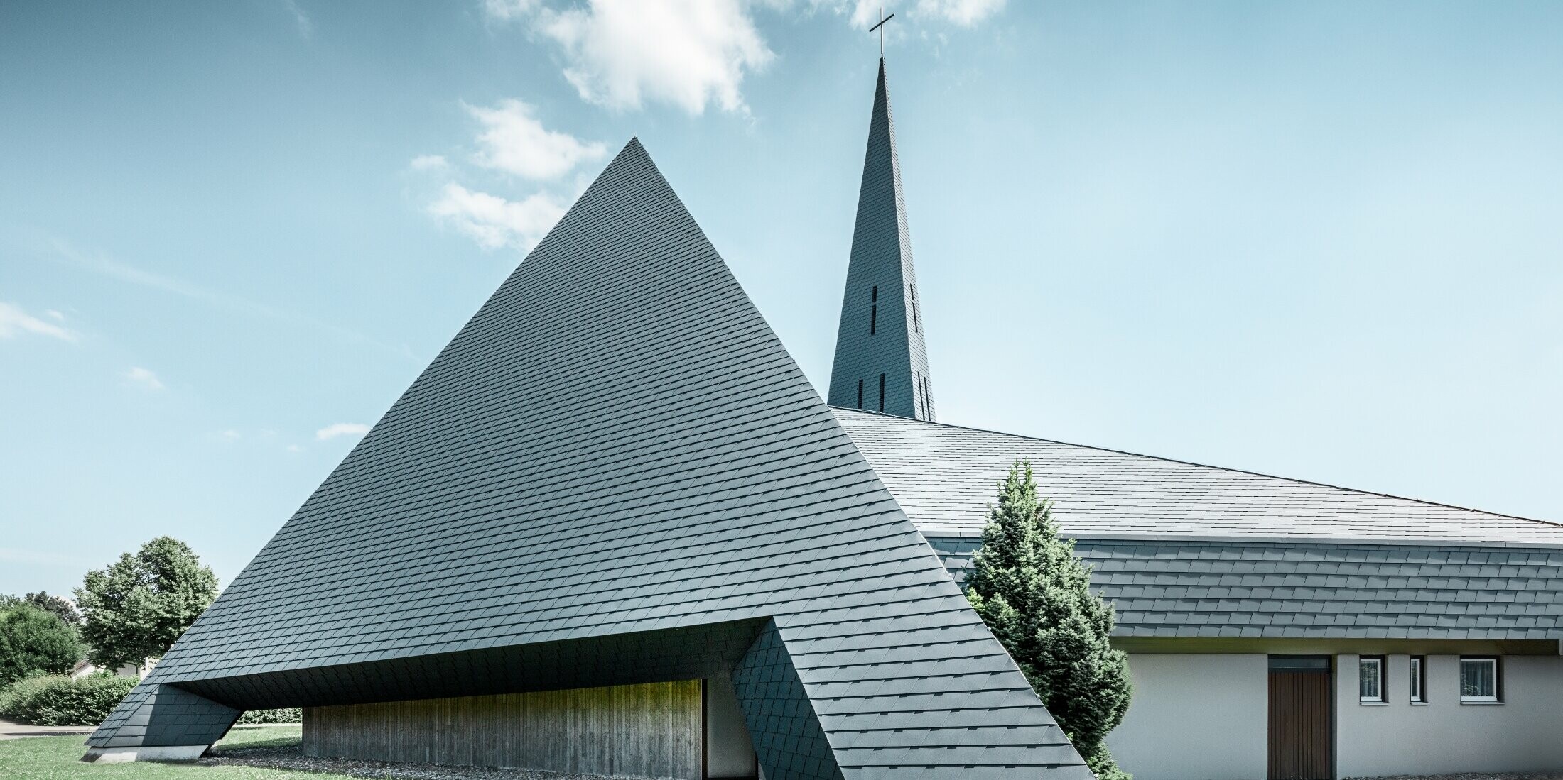 katholische Kirche in Langenau mit einem Design ähnlich einer Pyramide eingedeckt mit PREFA Aluminiumschindeln in anthrazit