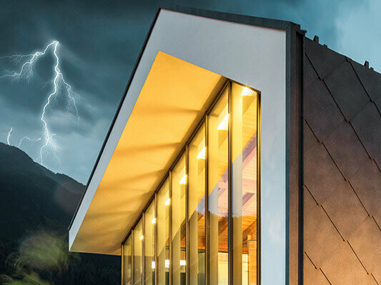 Photo d'une maison moderne sans surplomb de toit avec orage en arrière-plan avec la foudre