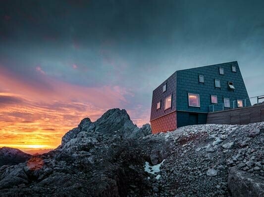 Une architecture hors normes dans les montagnes : le refuge Seethalerhütte sur le Dachstein est recouvert des panneaux de toiture et de façade FX.12 dans la teinte gris pierre.