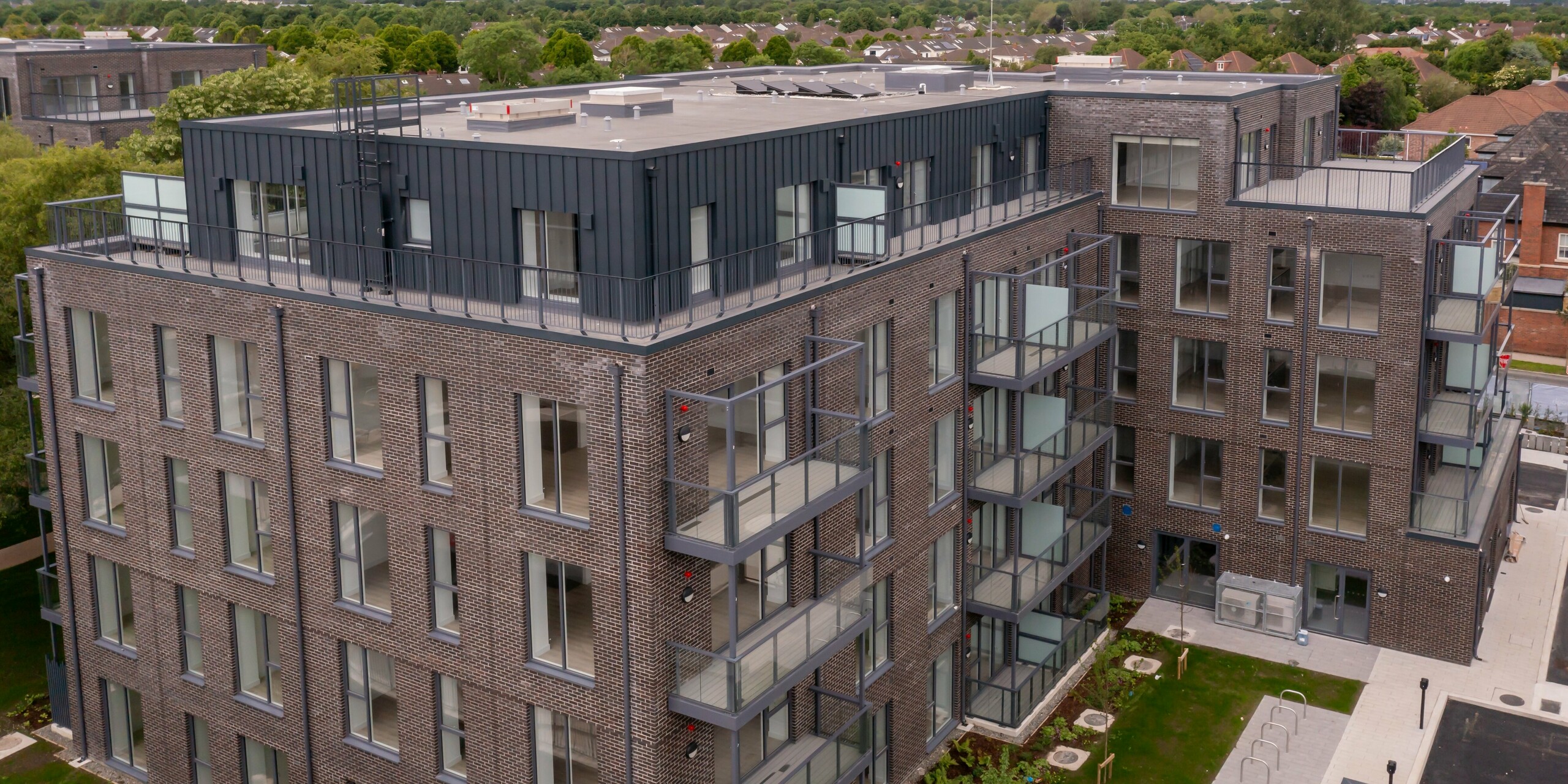 Vue de face du complexe résidentiel Balroy Hall à Dublin depuis une vue plongeante. Le bardage aluminium PREFALZ P.10 anthracite recouvre 800 m² de façade. Combinaison de haute qualité d'un design moderne, d'aluminium durable et d'une architecture traditionnelle en brique.