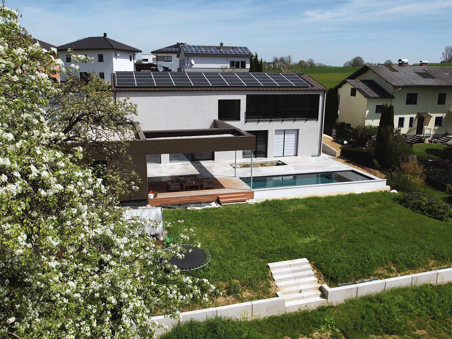 Blick auf den Garten des Einfamilienhauses in Peuerbach, links ist ein Ausschnitt einer Baumkrone zu sehen.