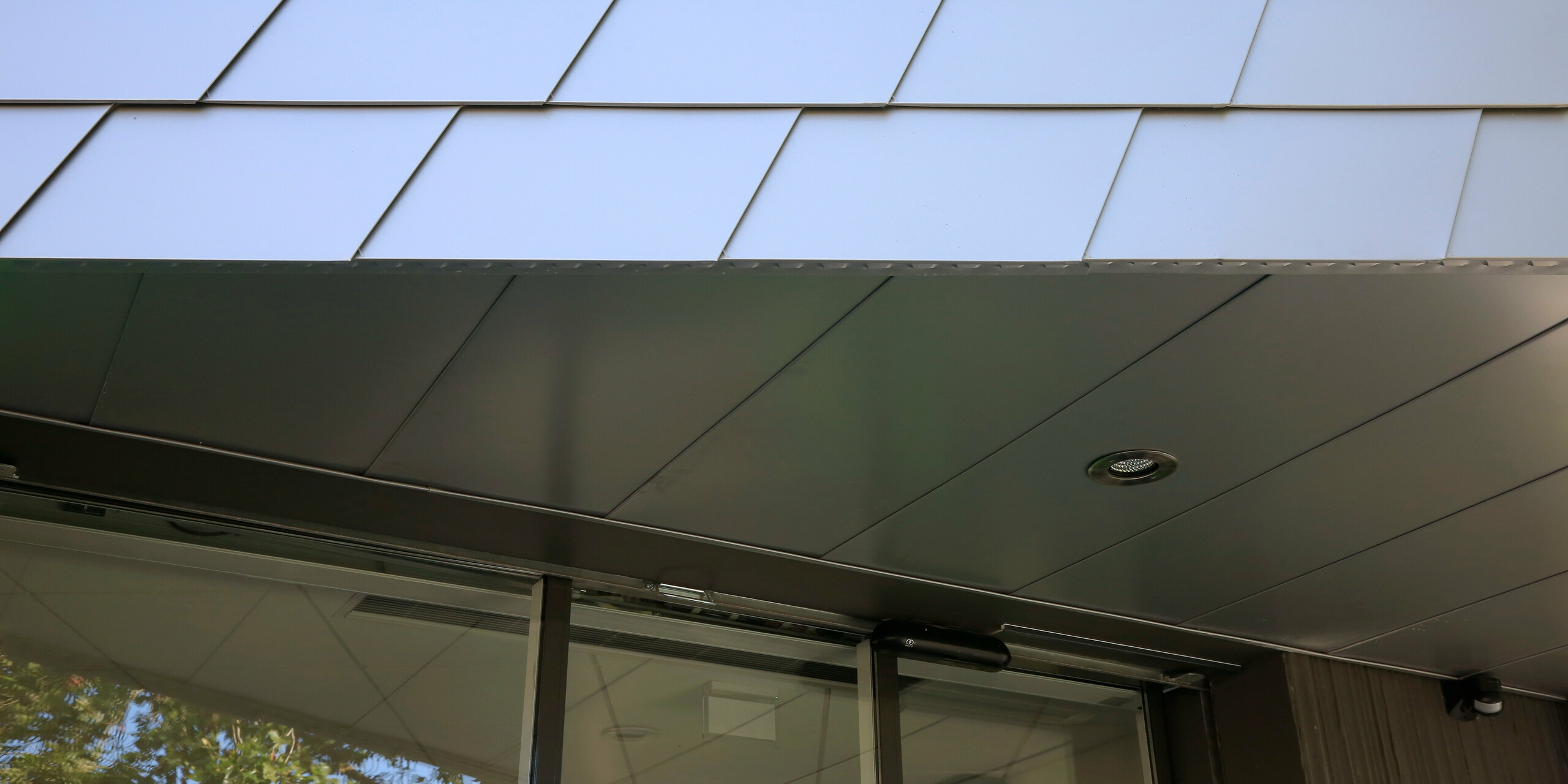 Vue détaillée de l'entrée du centre de santé du Landreau composé de bardeaux de façade PREFA en argent métallisé