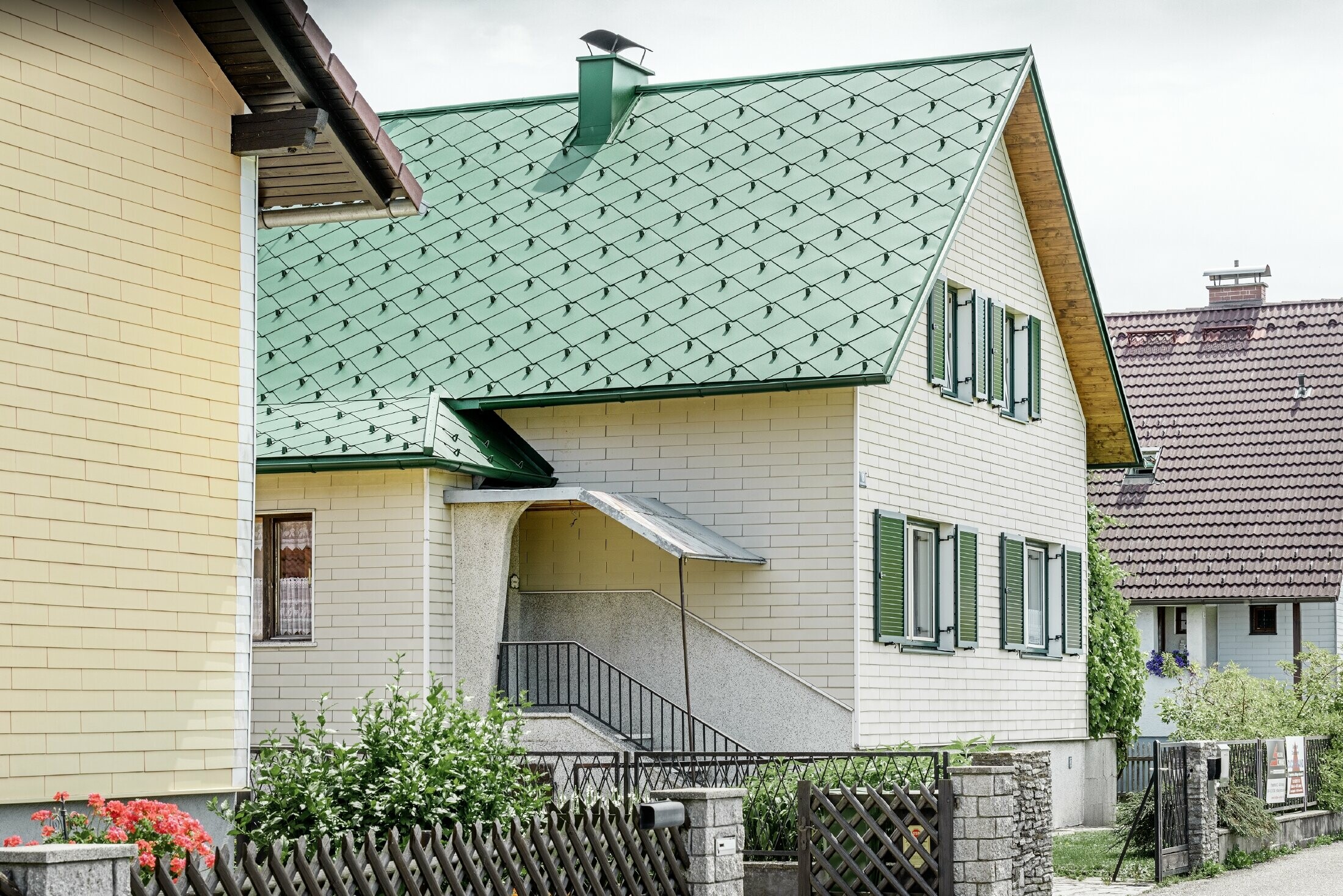 Maison individuelle classique au toit à deux versants dotée de volets verts — Couverture de toit en aluminium de couleur vert mousse