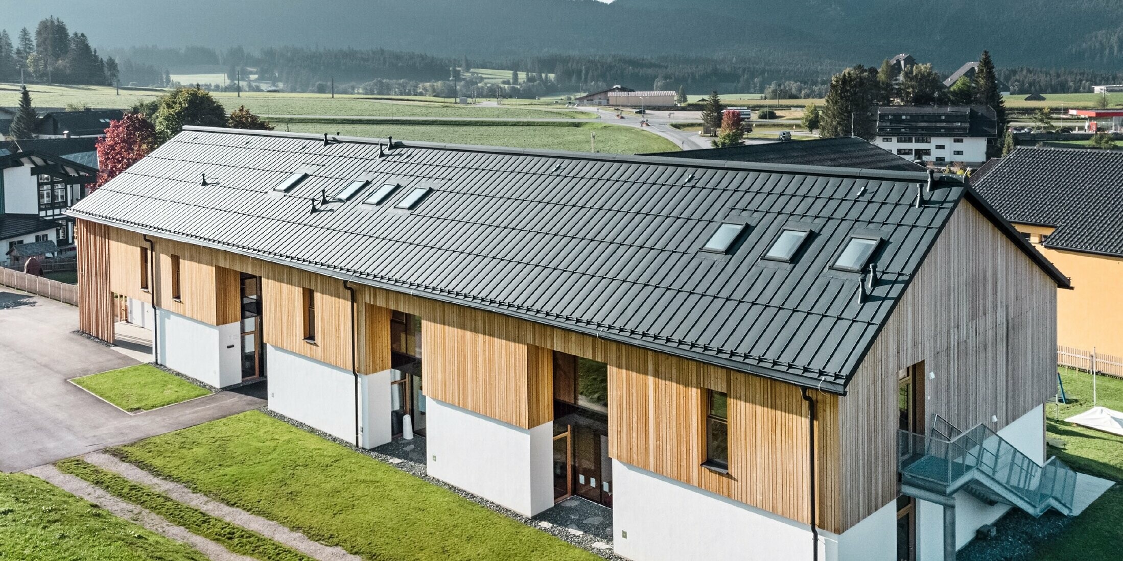 Kräuterkindergarten in Bad Mitterndorf mit großem PREFALZ Dach in P.10 Anthrazit und Holzfassade