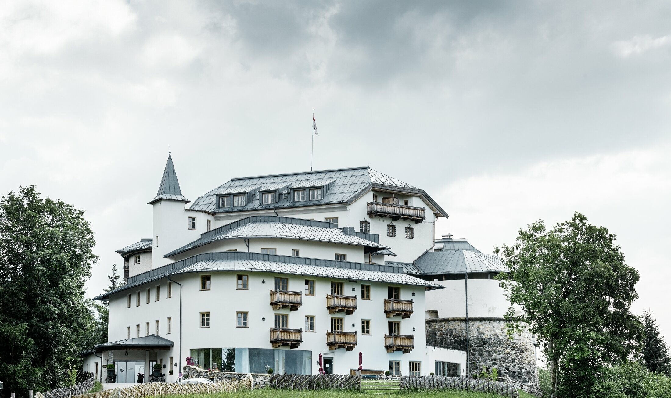 Château de Mittersill entouré d’arbres et de montagnes — Toiture rénovée avec des bandes Prefalz de couleur gris pierre