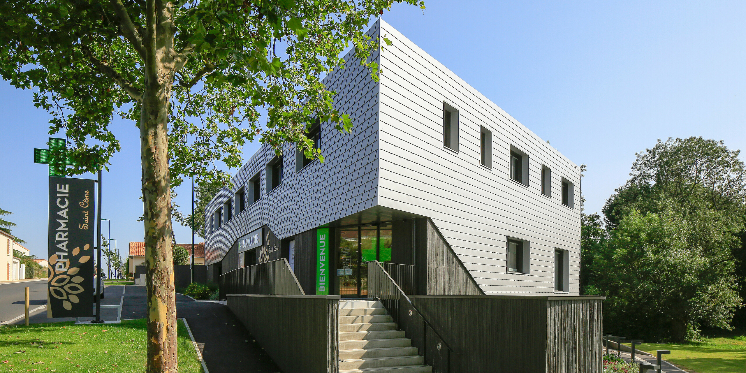 Arrière du centre de santé argenté scintillant du Landreau avec un escalier et des arbres verts en arrière-plan