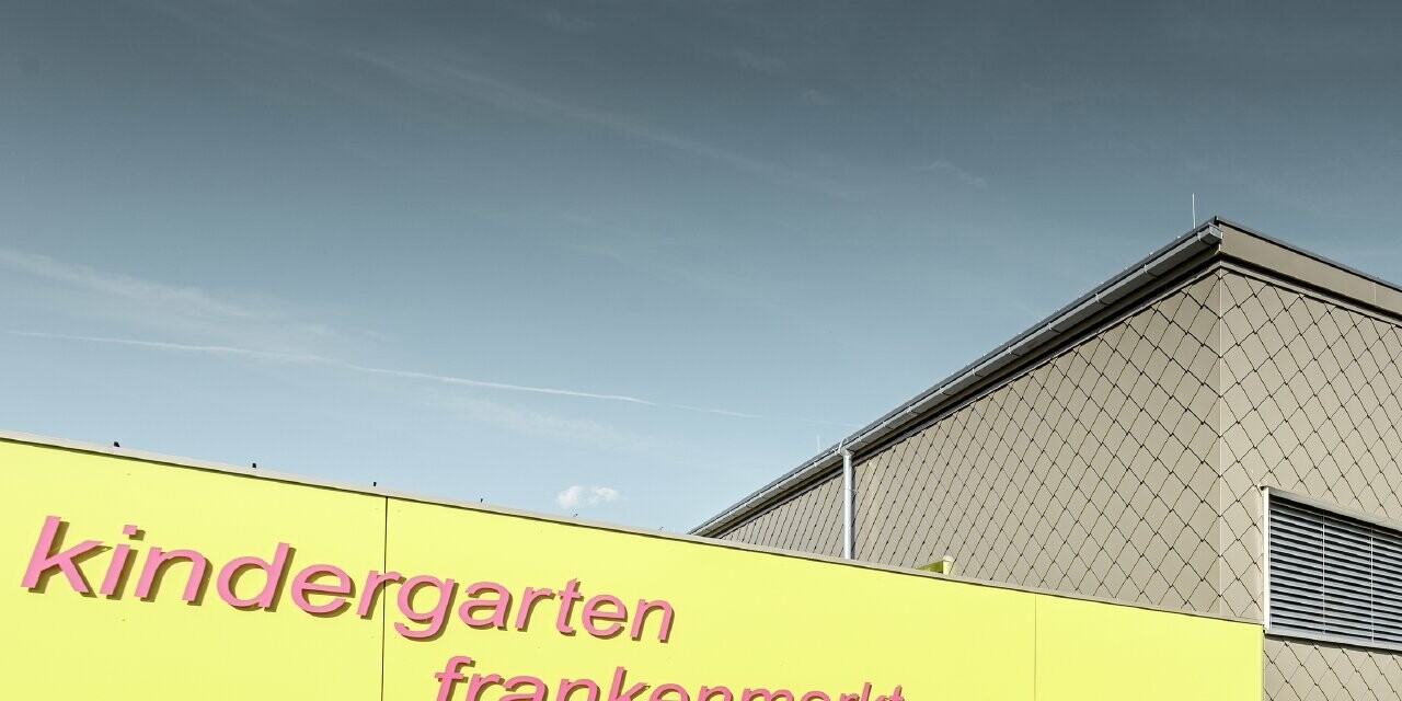 La façade du jardin d’enfants de Frankenmarkt a été partiellement habillée avec le losange de façade PREFA couleur bronze. Le reste de la façade a été habillé de panneaux de façade couleur jaune. On reconnaît aussi le nom du jardin d’enfants.