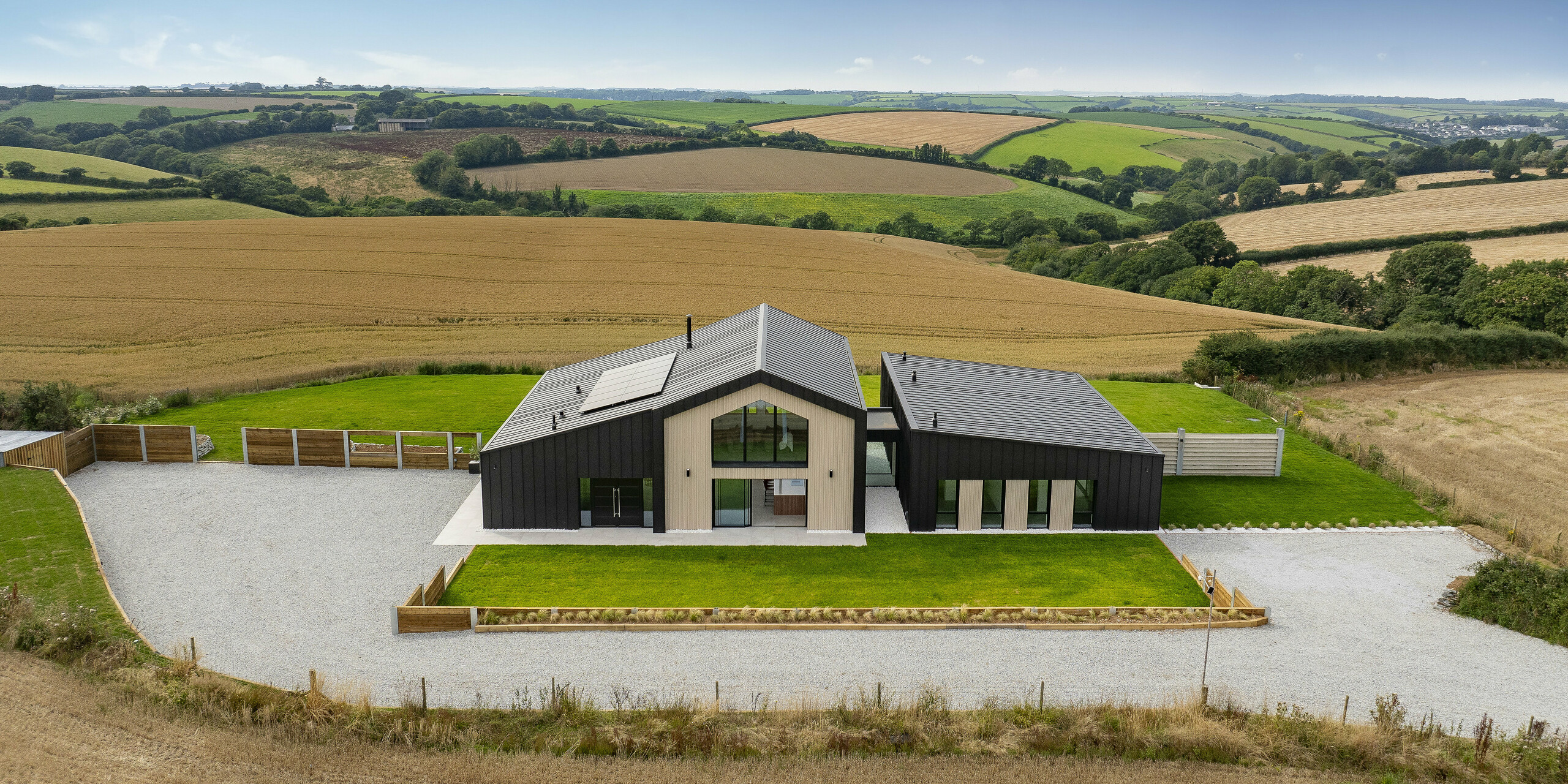 L'impressionnante maison individuelle « The Hide » à Cornwall s'intègre harmonieusement dans le vaste paysage. L'architecture moderne avec toiture et façade en aluminium PREFALZ en P.10 anthracite confère à la propriété une élégance intemporelle. Les champs et les collines environnantes soulignent l'emplacement unique.