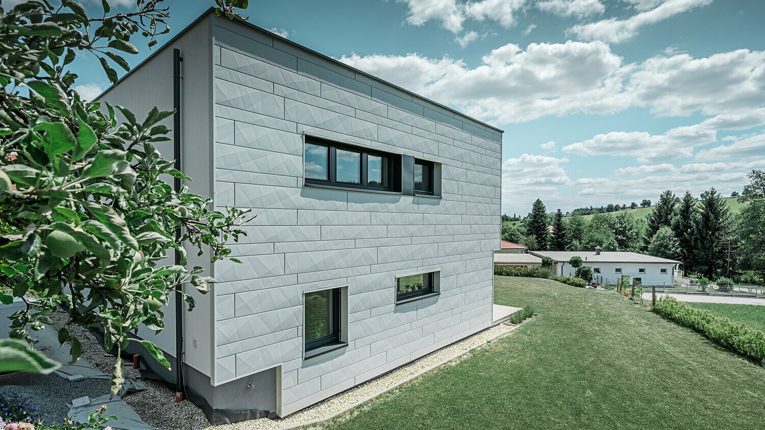 Vue latérale d’une maison individuelle moderne, avec façade en Siding.X visible.