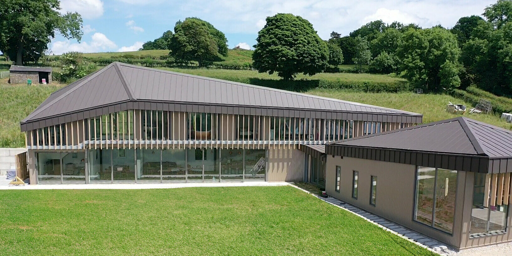 Seitliche Perspektive auf Langhaus in Derbyshire mit Dach aus PREFALZ in P.10 Braun