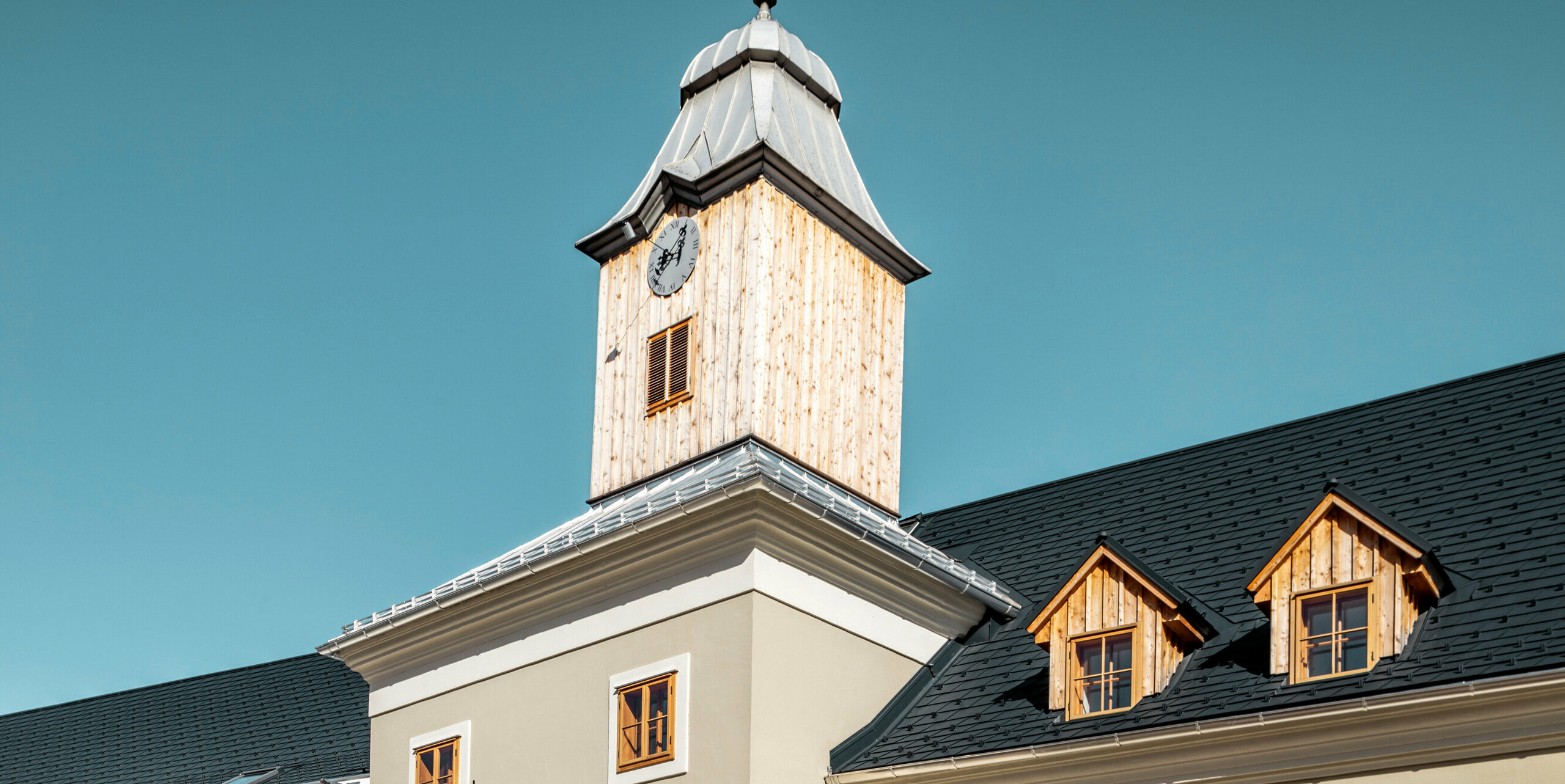 Le toit de l'hôtel Glockenturm à Marktl près de Lilienfeld a été recouvert de bardeaux PREFA en anthracite P.10. Le système de drainage du toit PREFA du bâtiment reste naturel. Non loin de l'hôtel Glockenturm se trouve le Leopold - notre auberge. Le bâtiment du restaurant a également été recouvert de produits PREFA.