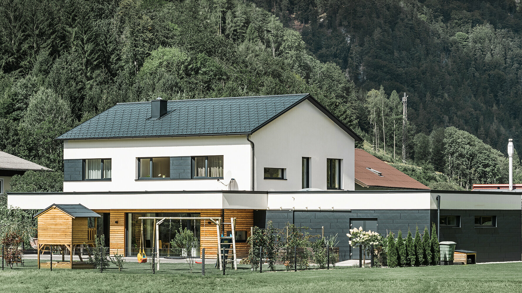 Nouvelle construction de maison individuelle avec façade en mélèze associée aux Siding.X PREFA couleur anthracite.