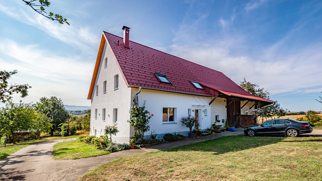 Ancienne fermette à la campagne joliment rénovée avec la tuile PREFA couleur rouge oxyde.