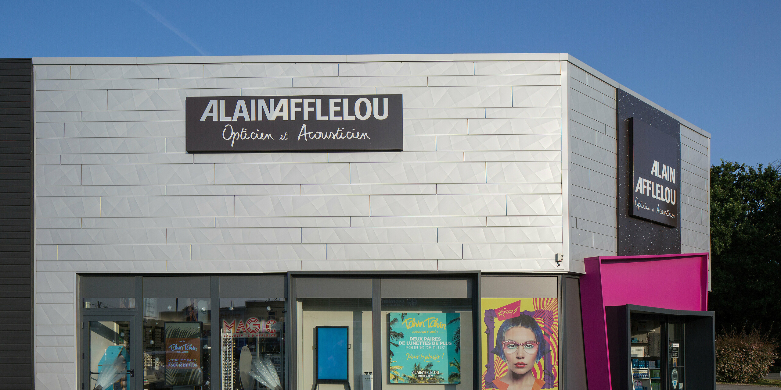 Vue latérale de l'atelier d'optique et d'acoustique AFFLELOU à Auray avec une coque de bâtiment en aluminium argenté