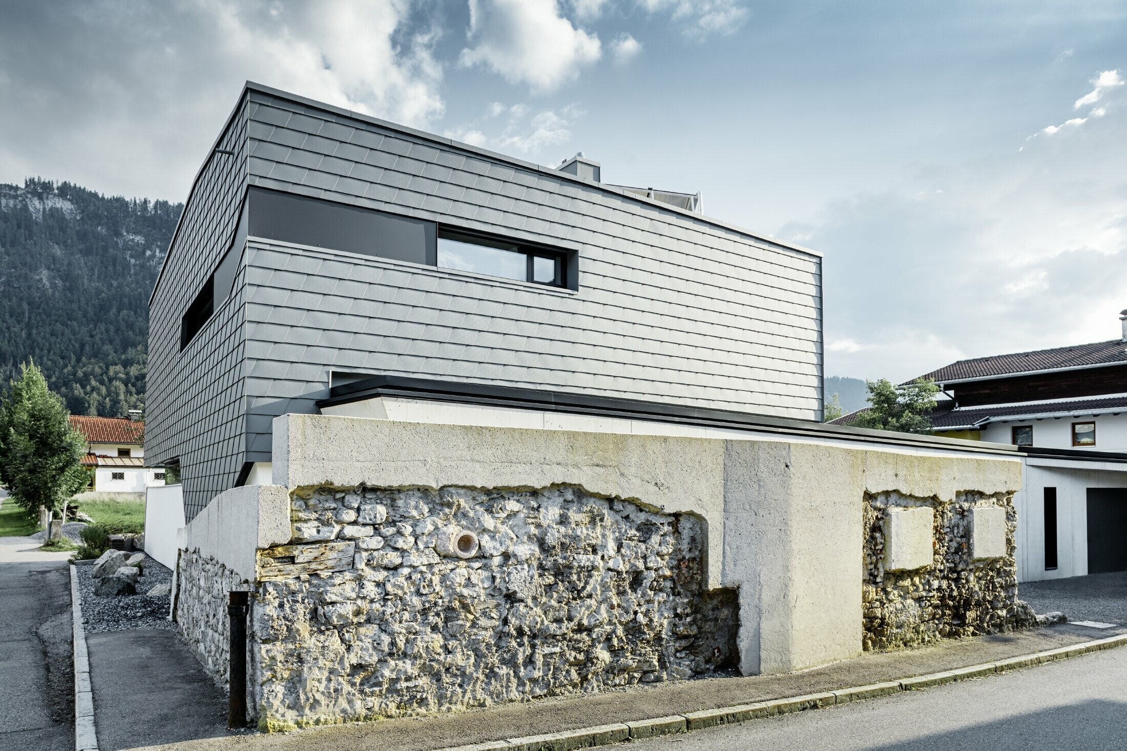 Maison individuelle moderne au toit plat avec de grandes baies vitrées — Façade réalisée avec des bardeaux PREFA en aluminium de couleur gris souris