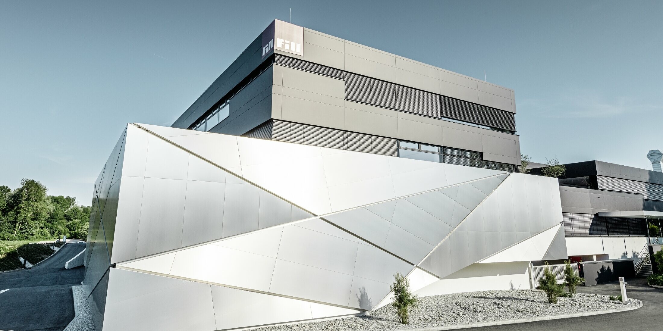 Fill Firmengebäude mit futurischer Aluminium Verbundplattenfassade in aluminium gebürstet und hinterleuchtetem Fugenbild