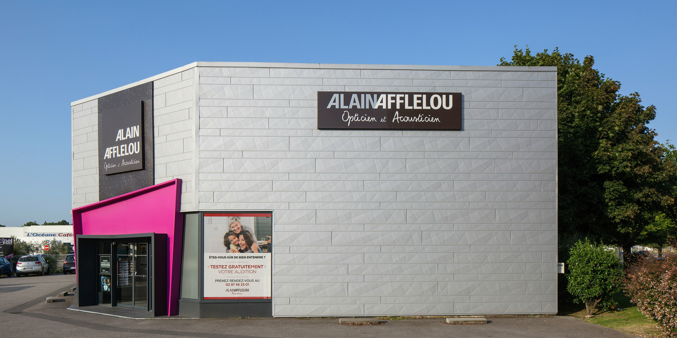 Perspective latérale du magasin d'optique et d'acoustique AFFLELOU à Auray avec une façade composée de PREFA Siding.X en argent métallisé