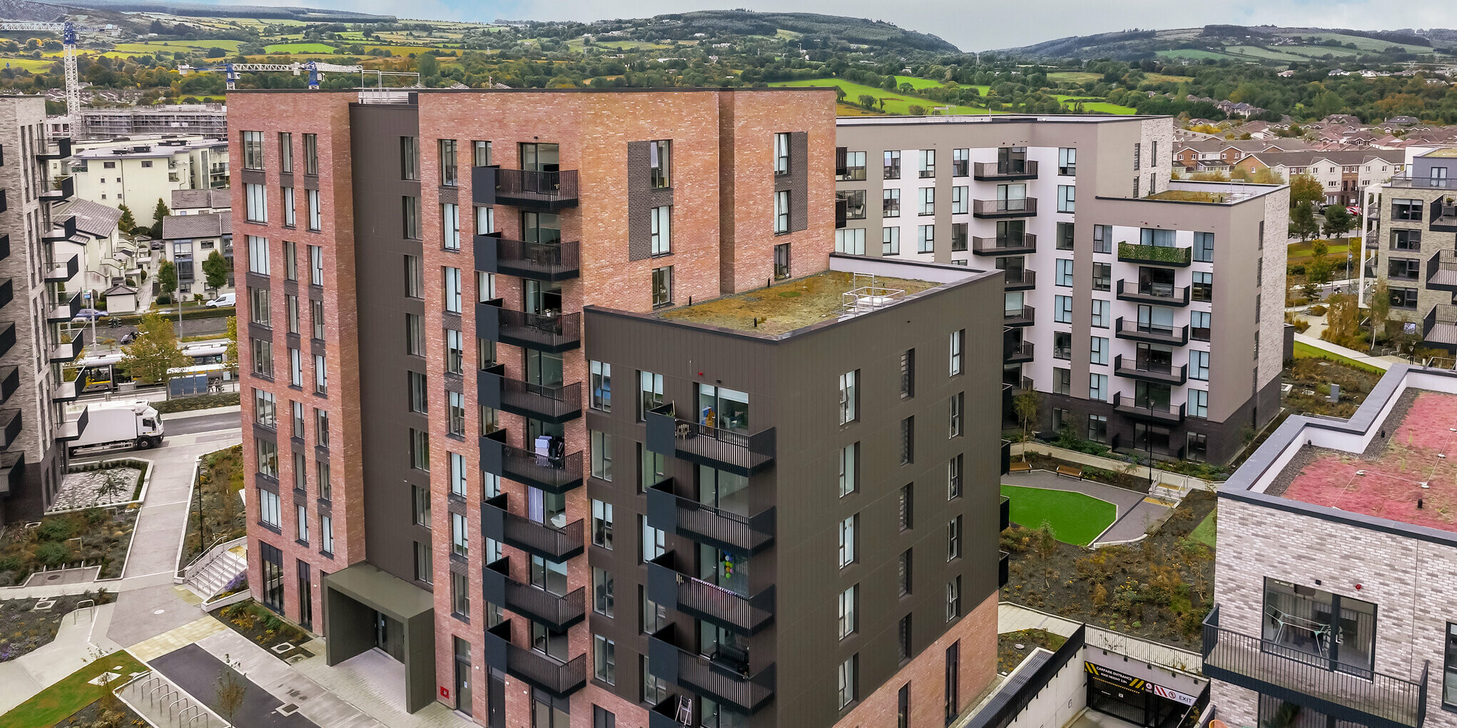 Vue aérienne des Citywest Apartments à Dublin. Les revêtements PREFA posés verticalement en P.10 brun sur environ 700 m² complètent la façade traditionnelle en briques. L'architecture moderne et la façade en aluminium durable combinent un design attrayant et une résistance aux intempéries.