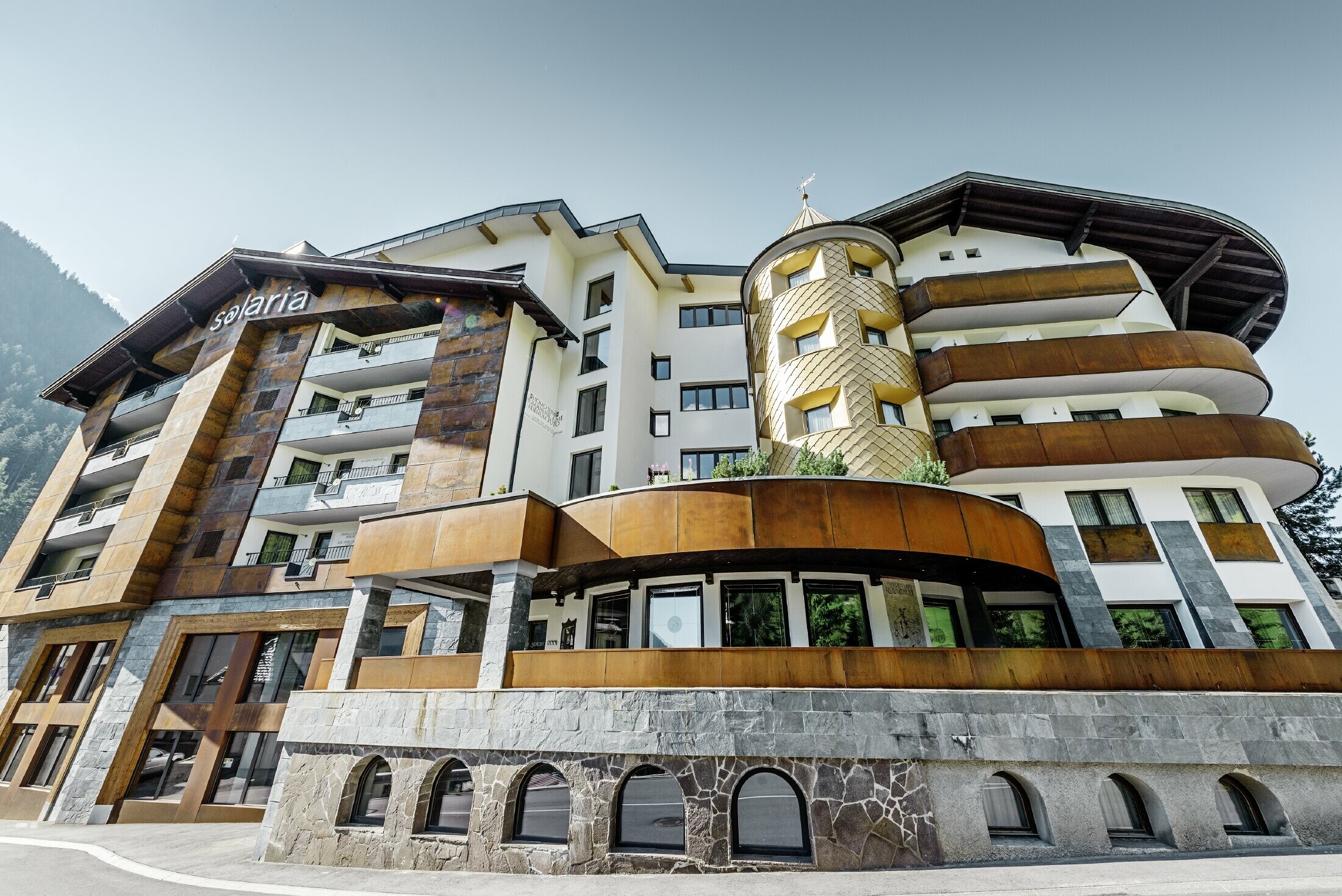 Hôtel traditionnel d’Ischgl avec balcons et façade en bois — Façade de la tour habillée de losanges en aluminium PREFA de couleur or