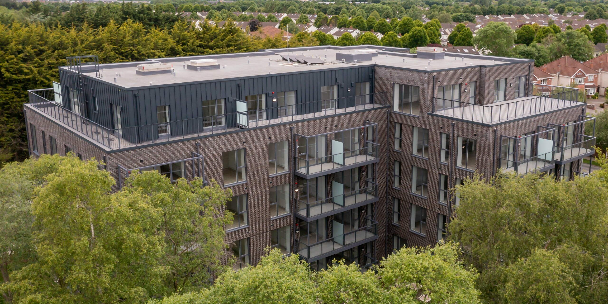 [Translate to Français:] Luftaufnahme der Wohnanlage Balroy Hall in Carpenterstown, Dublin. PREFALZ P.10 anthrazit auf 800 m² wurde an der Fassade der Gebäude mit traditionellen Ziegelfassaden kombiniert. Perfekte Harmonie zwischen moderner Aluminiumverkleidung und klassischem Design in nachhaltiger Architektur.